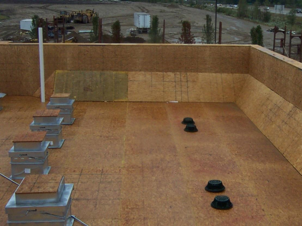 Flat roof covered in plywood, ready for weatherproof industrial shingles.